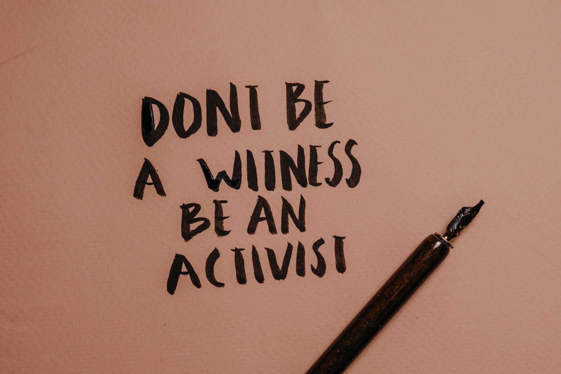a close up shot of a handwritten quote beside a fountain pen